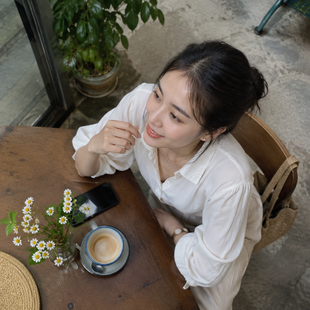 Người phụ nữ mặc áo sơ mi trắng, phối cùng phụ kiện tinh tế, thể hiện phong cách thanh lịch